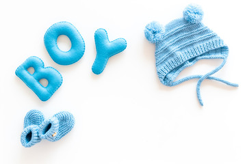 Children's birthday concept. Word boy near booties on white background top view frame copy space