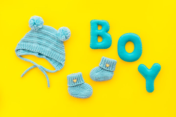 Children's birthday concept. Word boy near booties on yellow background top view