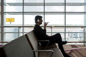 Man talking over the cell phone while waiting on an airport
