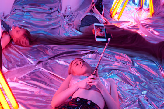 Trendy Model In Neon Lights Taking Selfie