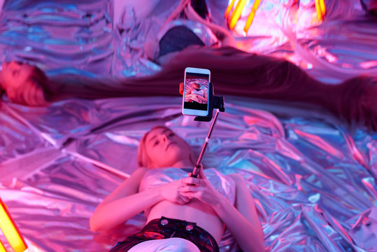 Young Woman With Monopod In Neon Light