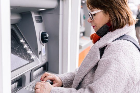 Adult female using ATM on street