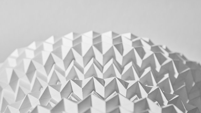 A pattern of embossed white semi-circle paper presented on a gray background with copy space. Macro photo