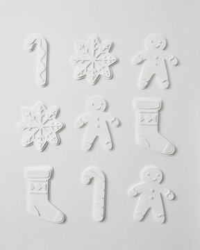 Pattern from volumetric paper figures in the form of snowmen, snowflakes, socks and candy on a gray background. Christmas composition as a layout. Flat lay