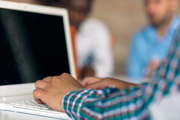 hands with laptop typing with people in background