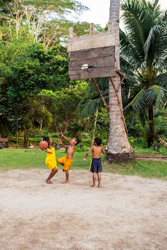 Asian kids playing basketball in the jungle