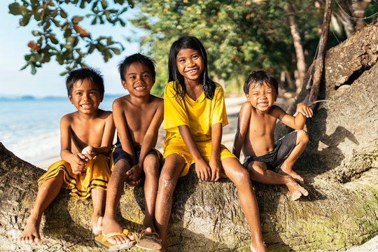 Cheerful kids sitting on tree trunks