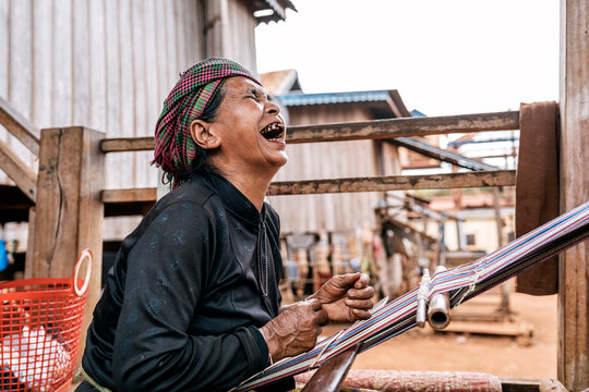 Cheerful elderly woman weaving on street