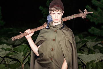 Portrait of a young handsome guy in fashionable clothes in khaki style at night