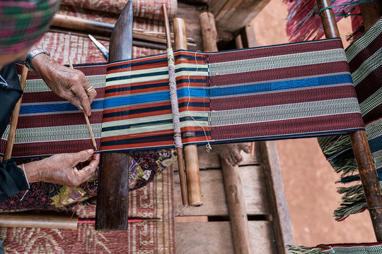 Close up of elderly woman weaving on street