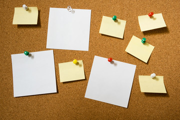 Note paper sheets pinned to a cork board with push pins. Office style design.