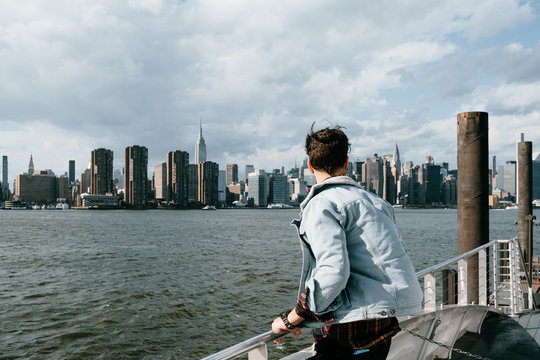 young and attractive man enjoys the views of new york from a boat
