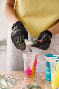 Woman mixing bright colors in cups