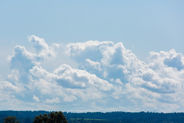 Big and thick clouds on the horizon. Blue sky with thick clouds.