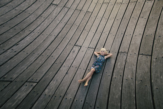 Little girl lying on wooden floor