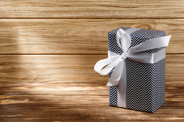Gift box with ribbon on wooden background top view. 