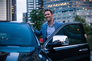 Smiling Man Getting Inside Car On Street