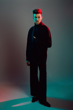 Young man wearing trench coat in studio.