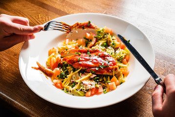man eating pasta with chicken and vegetables