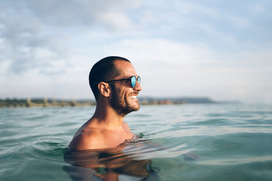 Smiling man swimming in sea water