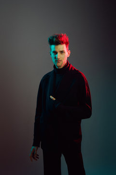 Young man wearing trench coat in studio.