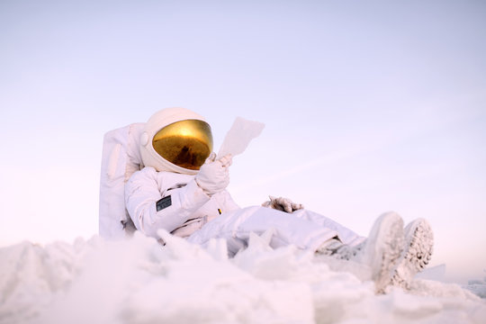Astronaut reading letter on cold planet