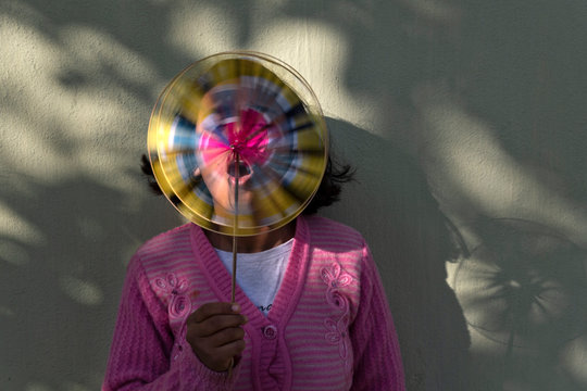 Teenage girl blowing pinwheel toy