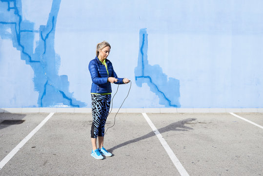 Aged fitness woman using skipping rope.