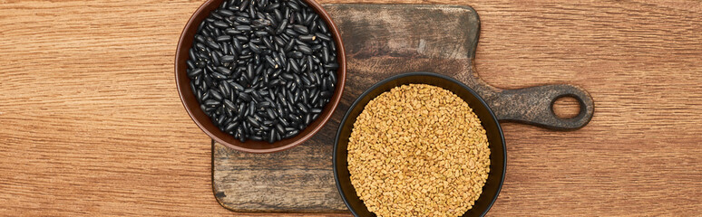 panoramic shot of bowls with beans ang grains on wooden cutting board