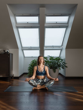 Woman meditating on mat at home