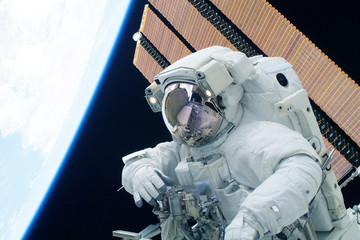 Astronaut in a spacesuit at the space station. Elements of this image were furnished by NASA