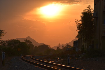 sunset between mountains and railway track