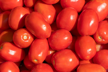 Tomato vegetables stacked on a surface as background.