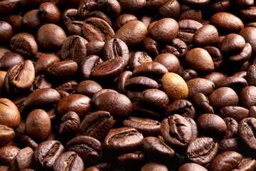 Background, texture of roasted brown coffee beans, close-up