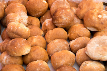 Traditional village breads stacked on a surface as background.