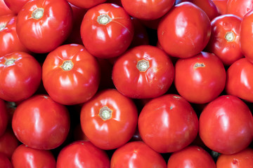 Tomato vegetables stacked on a surface as background.