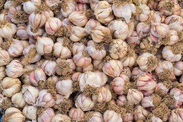 Garlic vegetables stacked on a surface as background.