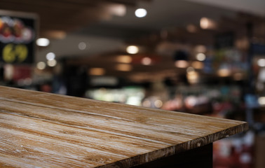 Empty dark wooden table in front of abstract blurred bokeh background of restaurant . can be used for display or montage your products.Mock up for space.