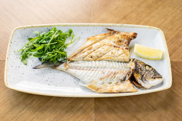 Plate Dorado with arugula and lemon. BBQ seafood. Restaurant menu