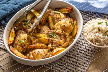 Chicken legs roasted with american potatoes in baking dish