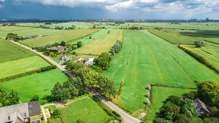 Fototapeta na wymiar Aerial drone view of green fields and farm houses near canal from above, typical Dutch landscape, Holland, Netherlands
