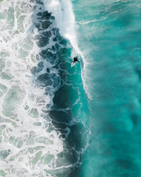 Aerial Sport Action Shot Of A Surfer At Sunrise Riding A Wave In A Blue Ocean In Sydney, Australia Bondi Beach