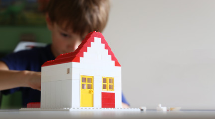 Boy builds a residential with building blocks