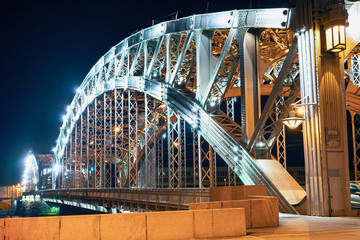 Obraz premium the beautiful metal bridge of Peter the Great across the Neva River in St. Petersburg against the night sky