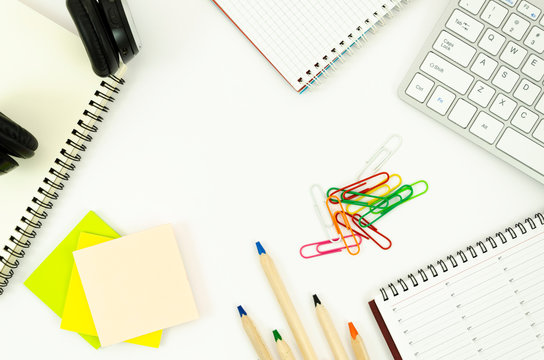 Top view frame office desktop with blank spiral notepads, sticky notes with copy space, big pencils and keyboard