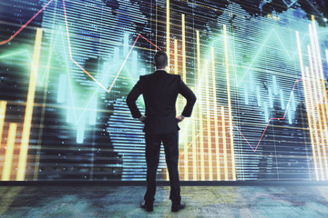 Obraz premium Businessman and forex graph and world map hologram. Double exposure. Concept of financial education and analysis
