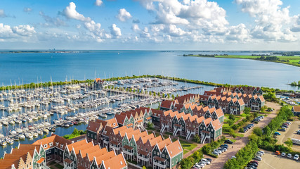 Aerial drone view of typical modern Dutch houses and marina in harbor from above, architecture of port of Volendam town, North Holland, Netherlands - obrazy, fototapety, plakaty