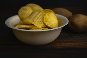 potato chips in bowl on wooden table