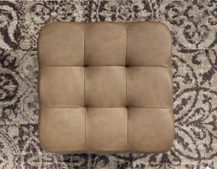 Top view of a squared elegant leather brown pouf. Beige carpet with motifs on background