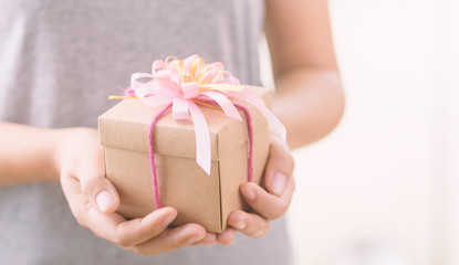 Woman holding gift box in hands for giving